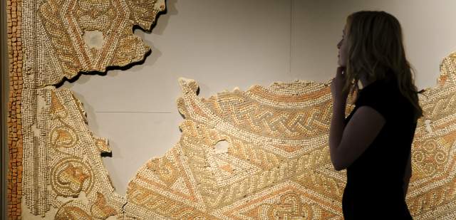 Person looking at a Roman mosaic at Fishbourne Roman Palace