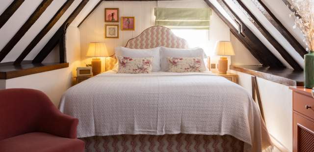 A hotel room with dark beams and a large comfy bed at the White Hart, Lewes