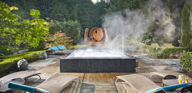Sun loungers surrounding a steaming hot tub in the Zen Spa, Alexander House