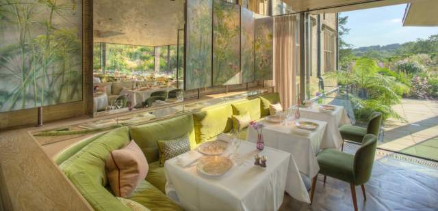 Interior tables at Gravetye Manor restaurant, with patio doors leading out to gardens