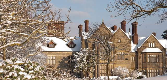 Snowy winter scene with a snow-topped stately home in Sussex