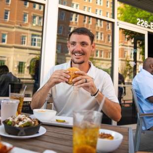 Man eating burger from Cribb's Kitchen