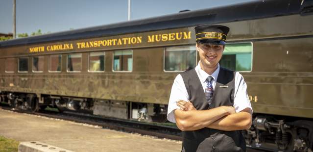 Conductor in front of train at the N.C. Transportation Museum