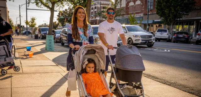 Family with kids in strollers walking downtown