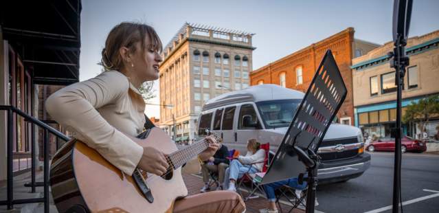 Girl playing guitar at Buskers' Bash