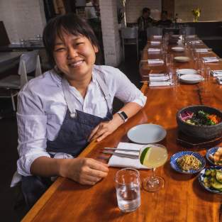 Chef Ji Hye Kim at a table of Korean food