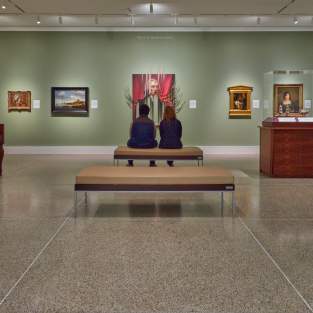 Couple sitting on bench in UMMA looking at painting