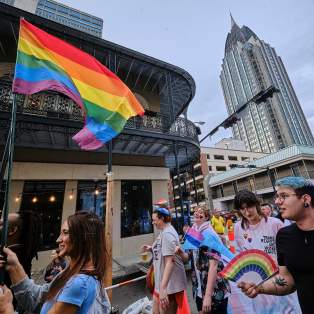 Group of people in the street with rainbow fan and a rainbow flag