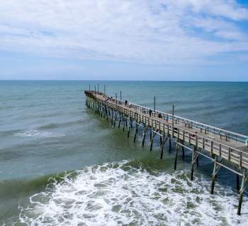 an aerial view of an ocean pier extending into the water