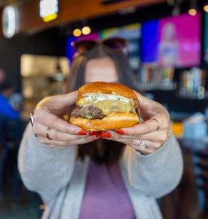 person holding up burger from salt block burger and brews in rapid city, sd