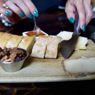 Charcuterie board with bread, nuts, cheese and preserves