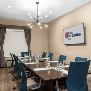 A long table with orderly office chairs and business papers set on the table