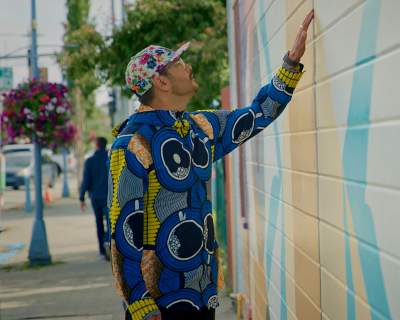 Artist Drew Michael looks at his mural on the side of the Kobuk.