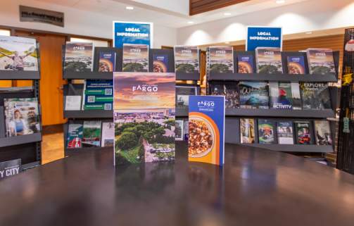 Fargo visitor guide and dining guide in front of brochure racks