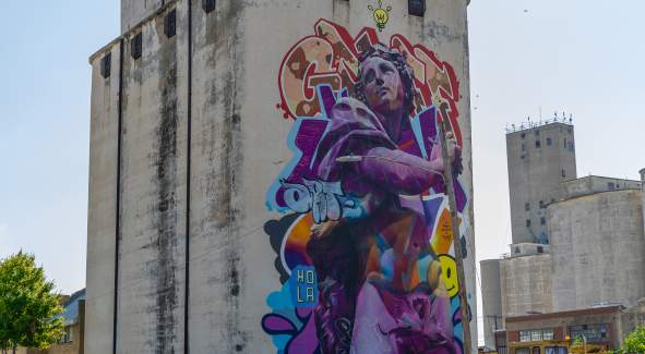BOOM! Mural, Dionysus by by artist PichiAvo painted on a large building in Salina, Kansas