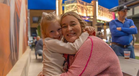 Mother and Daughter hugging at First Friday
