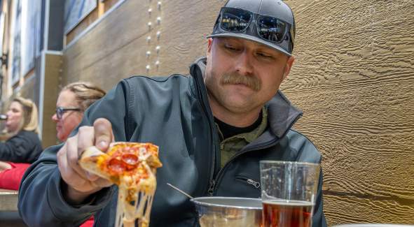 Guy eating pizza at Blue Skye Brewery and Eats in Salina, Kansas