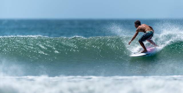 In a sunny day a surfer ride a wave at Playa Venao