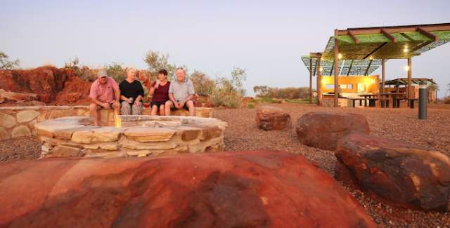 Campers sit by the campfire at Peedamulla Campground in the Pilbara
