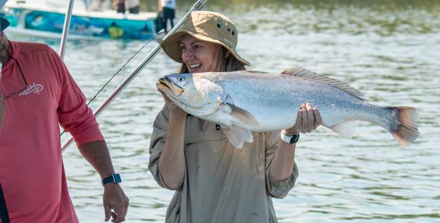 Individuals proudly displaying their freshly caught fish.