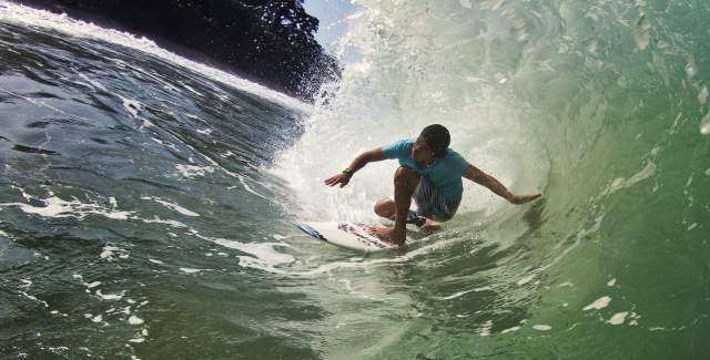 Surfer A surfer rides the perfect barrel in the pristine waters of Bluff Beach.