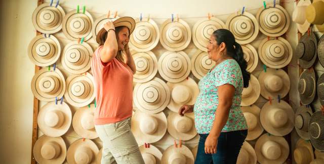 Tourist wearing sombrero pintao, at the background a group of hats displayed