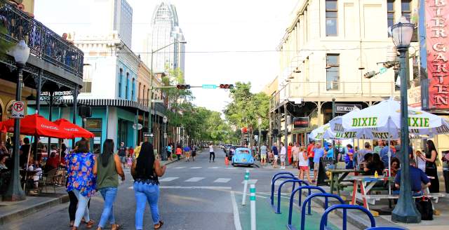 group of people walking down Dauphin Street