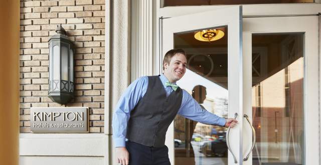 Staff opening the door to a Kimpton hotel