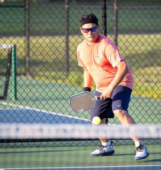 Pickleball player at Pioneer Park in Woodbury during a warm day.