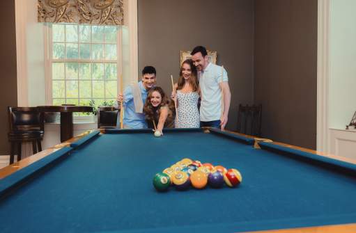 Friends playing pool at a bed and breakfast.