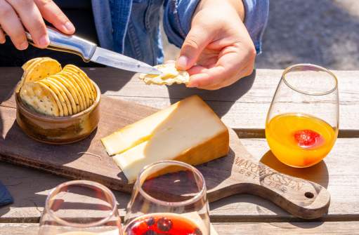 Hand spreading cheese on a cracker.