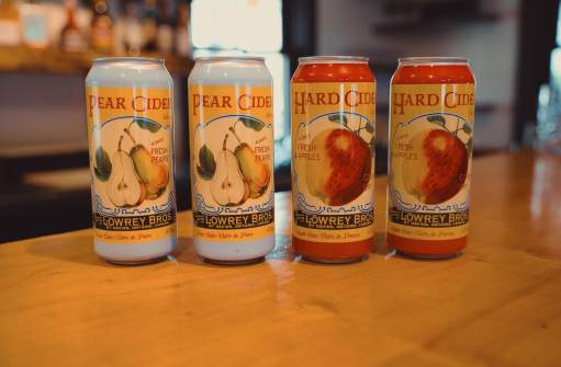 Four cans of cider sitting on a countertop