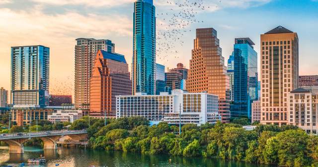bats flying from the congress bridge in front of Austin skyline at sunset