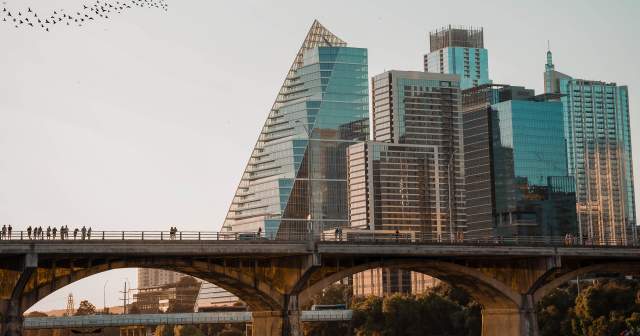 Austin city skyline with birds flying over a bridge at Lady Bird Lake
