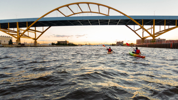two kayakers kayaking under the Hoan Bridge