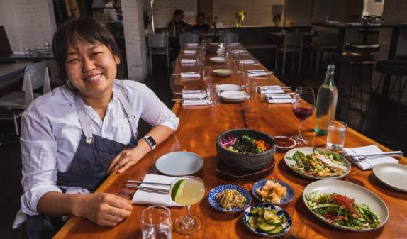 Chef Ji Hye Kim at a table of Korean food