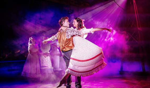 Man and woman dancing on stage during a production of Oklahoma