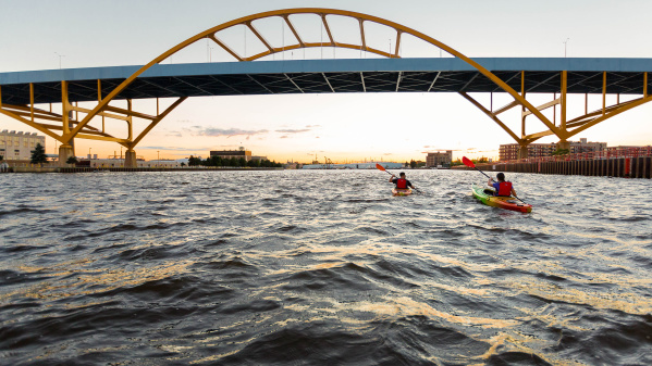 two kayakers kayaking under the Hoan Bridge