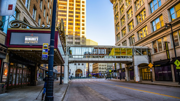an image of a city street with a theater marquee and a skywalk with Milwaukee Theater District branding