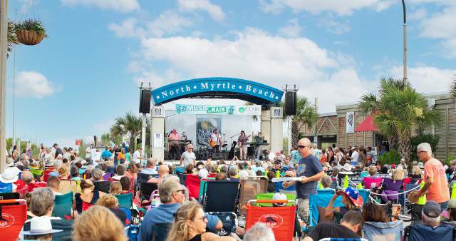 A crowd enjoys music on Main on a sunny day.