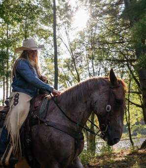 Woman horseback riding at 1000 Acres Ranch