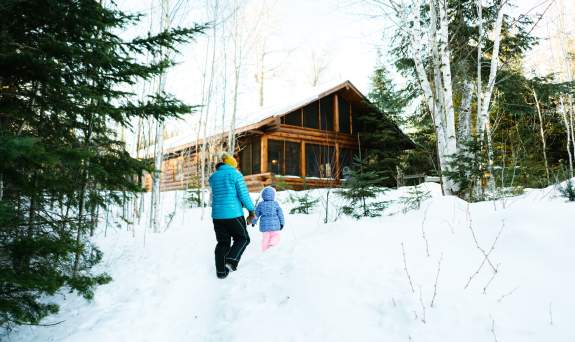 Winter cabin with family outside on Gunflint Trail