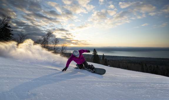 Snowboarder with Lake Superior in background at Lutsen Mountains