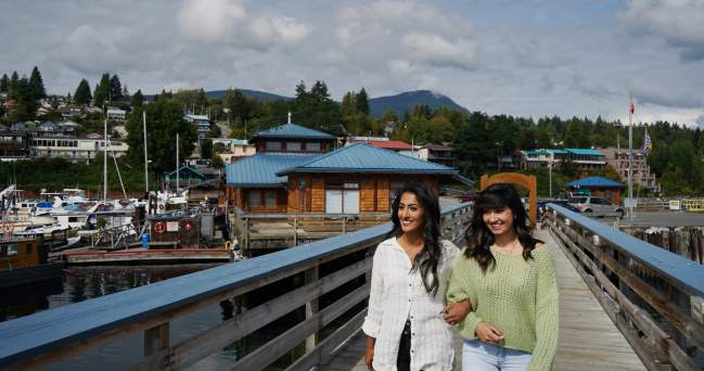 Two woman walk arm-in-arm in Gibsons.