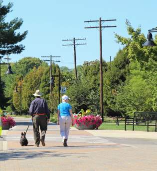 A senior couple walking with their dog on the B-Line Trail