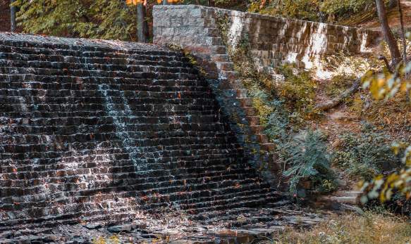 A man made waterfall created out of stone in the middle of a forest