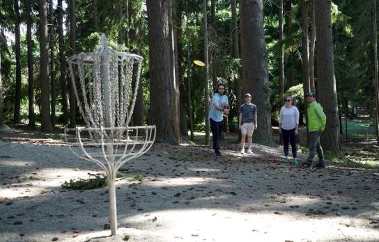 Group of friends playing frisbee golf in a forest