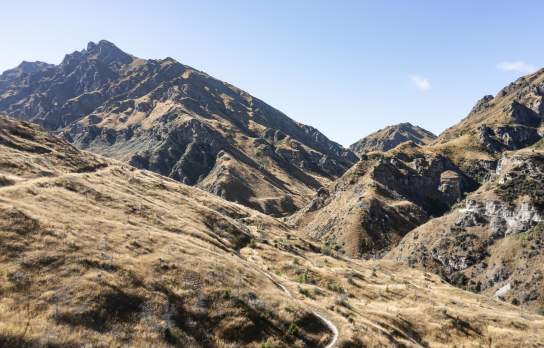 Wide view of a mountain bike trail through striking rugged mountains