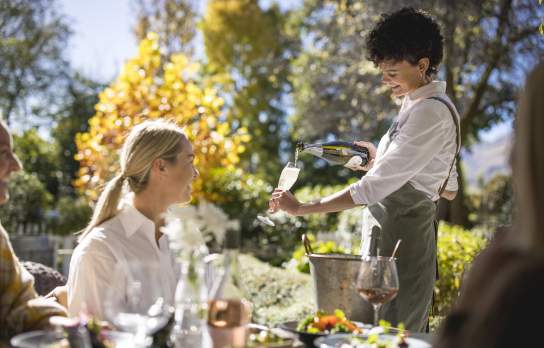 Waitress pouring champaign for guest