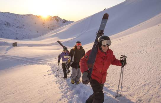 Group of people walking up The Remarkables Ski Area with skis